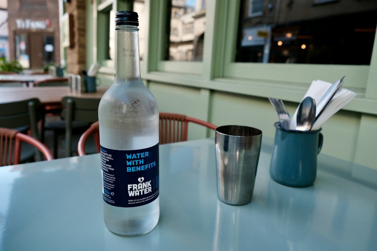 Reusable water bottle and a metal cup on a café table